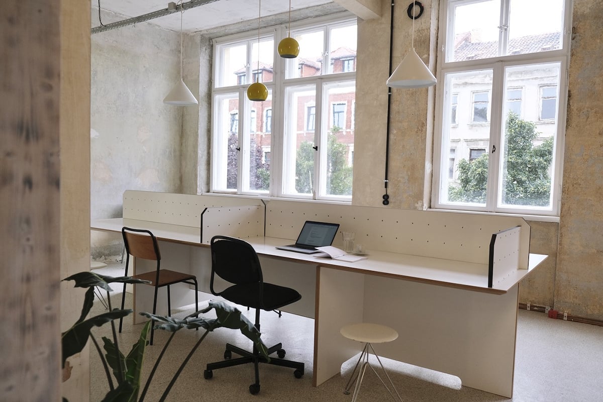 Coworking-Arbeitsbereich mit grossen Fenstern und hellen Arbeitsplaetzen